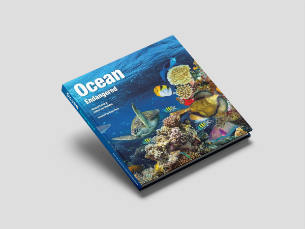 The front cover of the book "Ocean Endangered," featuring a dramatic depiction of endangered marine life and oceanic threats.