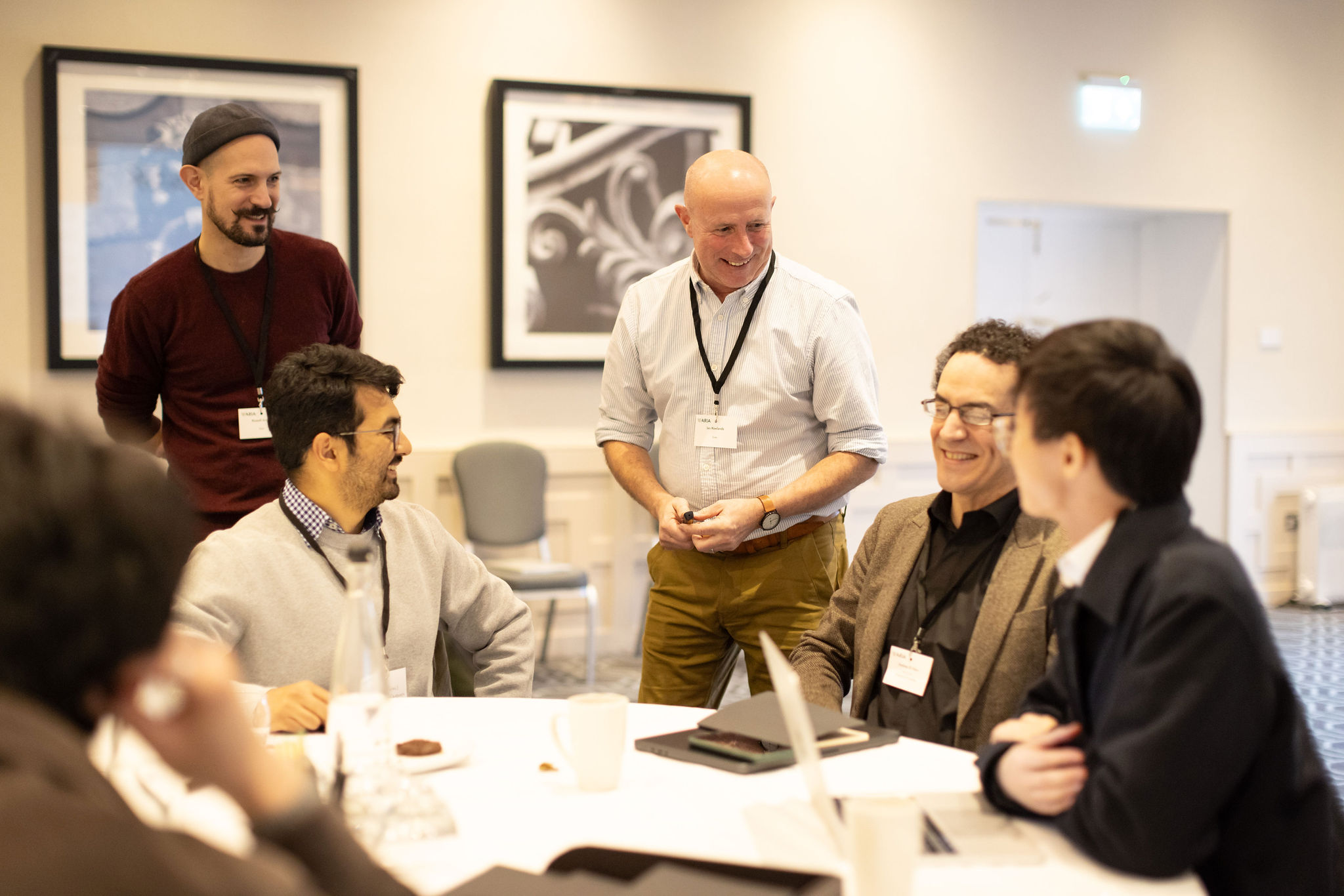Participants of training programme speaking with training Ian and Russell