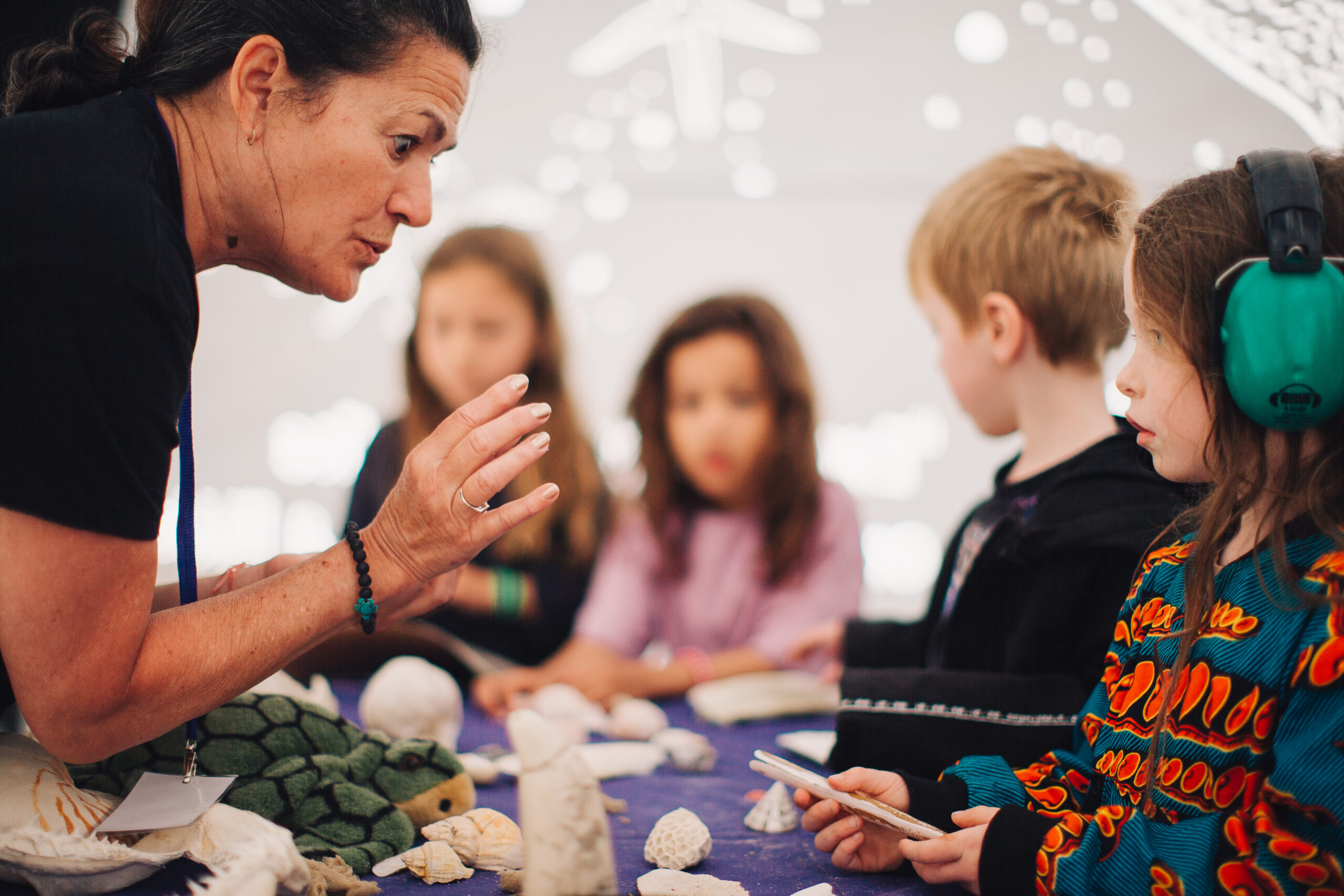 Gina Gow shows a marine artefact to a child inside the Incredible Oceans dome at First Light Festival